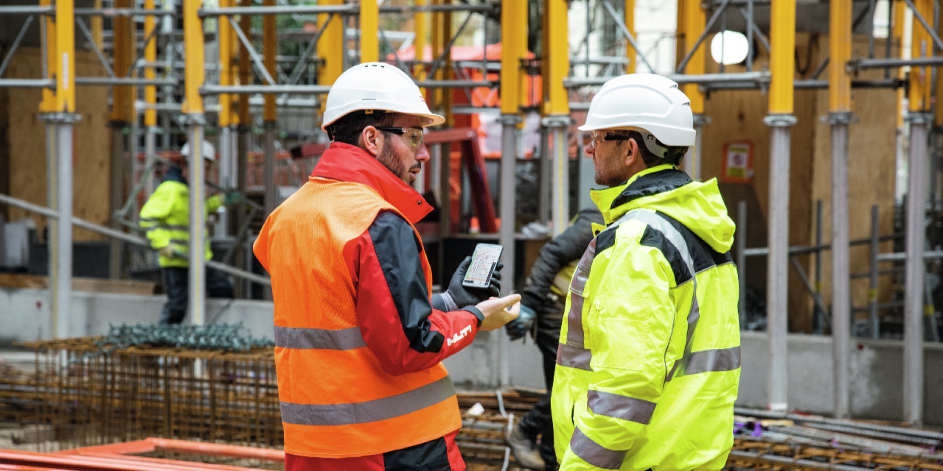 Baustelle, Arbeiter mit Hilti-Berater und Handy mit Hilti Construction Software